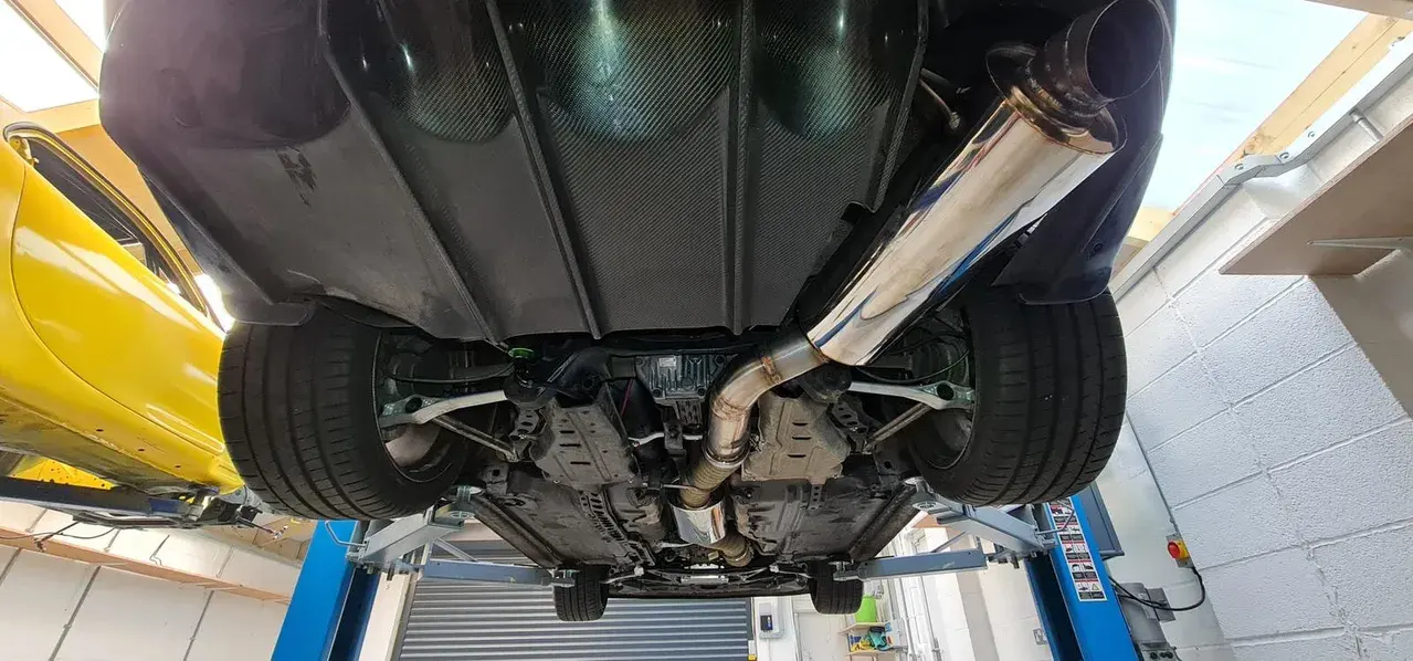 Underside view of a custom exhaust system on the lift